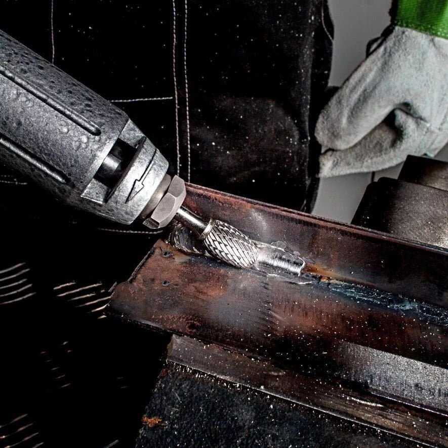workpiece secured in bench vise for rotary burr deburring operation